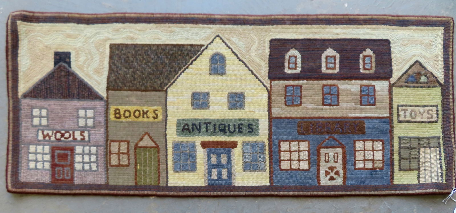 A small pictorial hooked rug depicting a town's store fronts, all wool in very good unused (1 of 4)