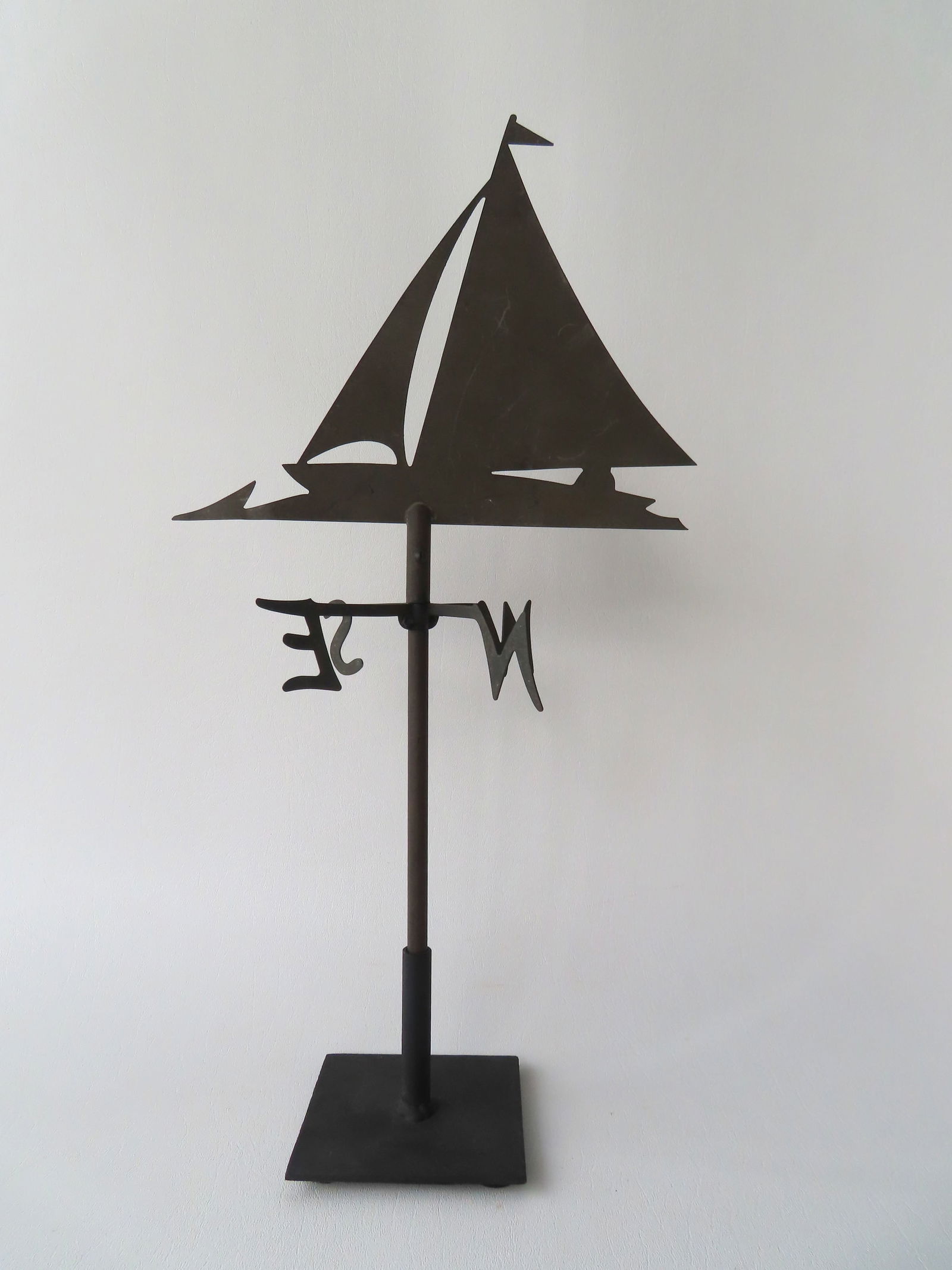 A small silhouette copper weathervane in the form of a sailing ship with directions, mounted on a (1 of 3)