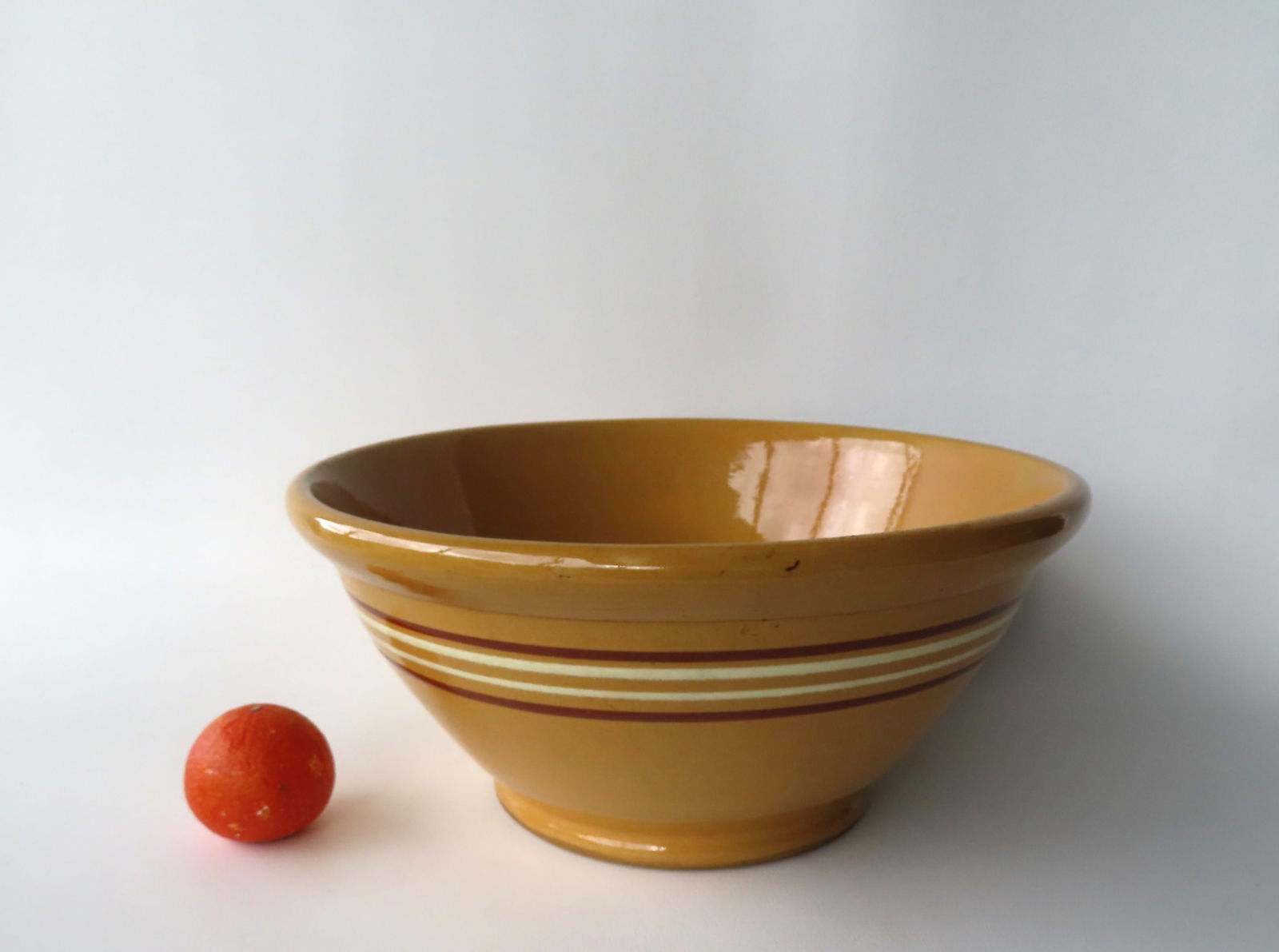 Very large yellowware mixing bowl with white and brown bands having a rolled rim and footed base, (1 of 5)