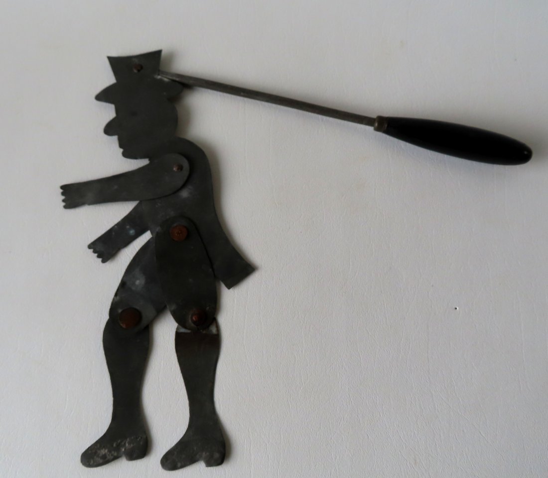 A hand cut tin articulated jump toy, 19th century.: A hand cut tin articulated jump toy with weighted shoes, attached to rod with wooden handle to make the man jump or dance, 19th century. One leg is disconnected and needs fixing, else good condition. 