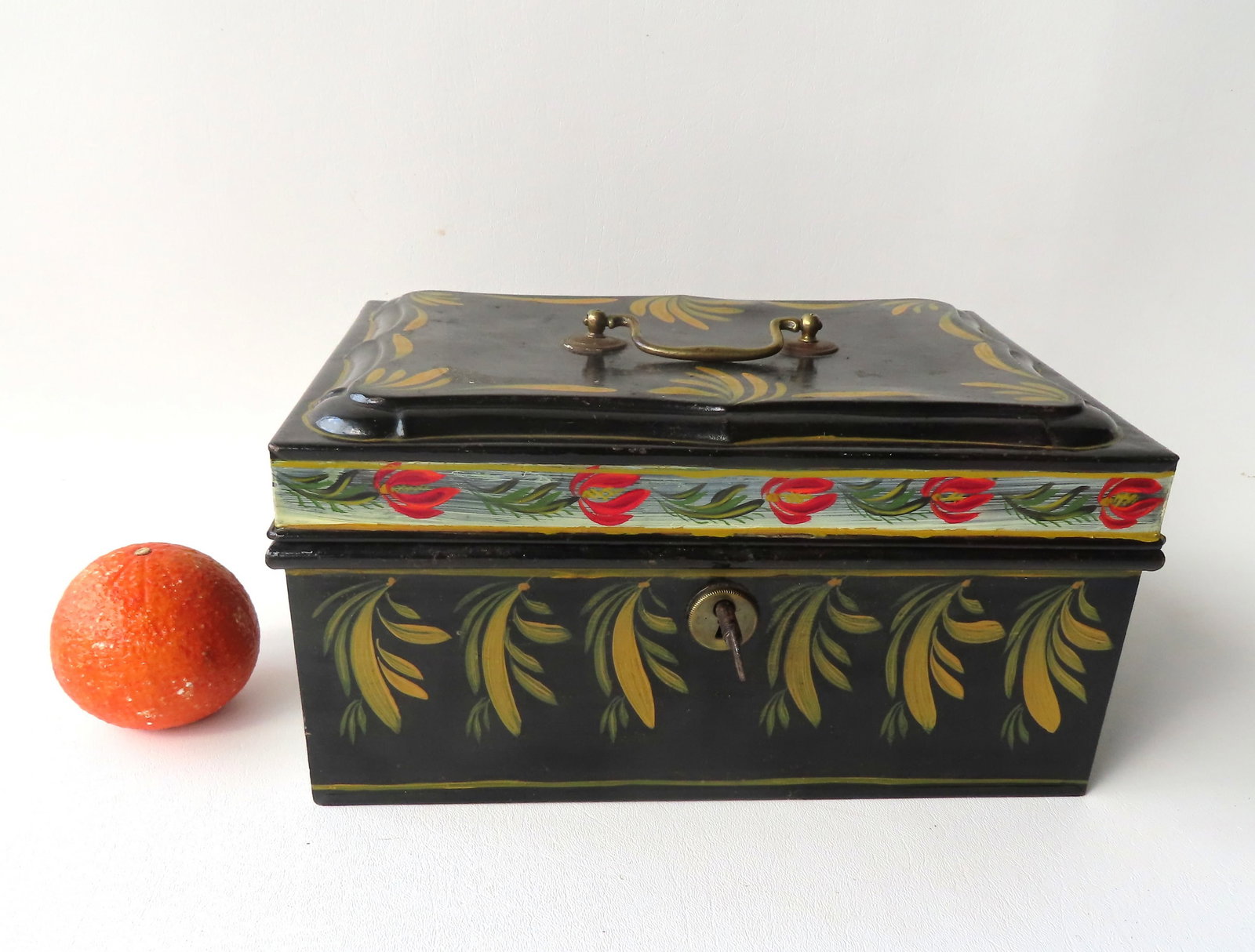 A toleware cash box, all hand painted, 19th century, with lock and key.: A toleware cash box, all hand painted, 19th century, with lock and key. The paint around the perimeter of lid may be a later paint, but the other paint appears to be original. Measures 11 3/4" x 8 1/2