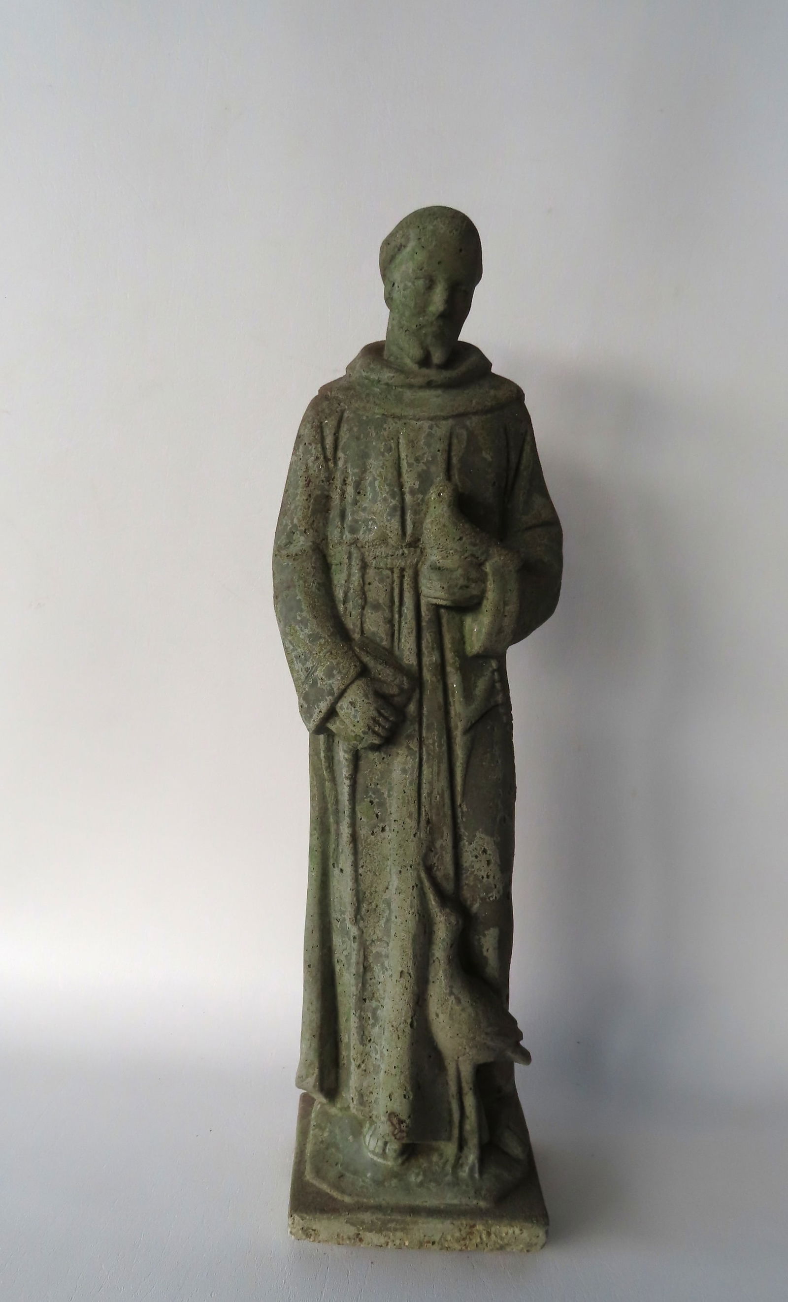 A vintage concrete garden statue of St. Francis holding a dove in one hand and a book in the other (1 of 4)