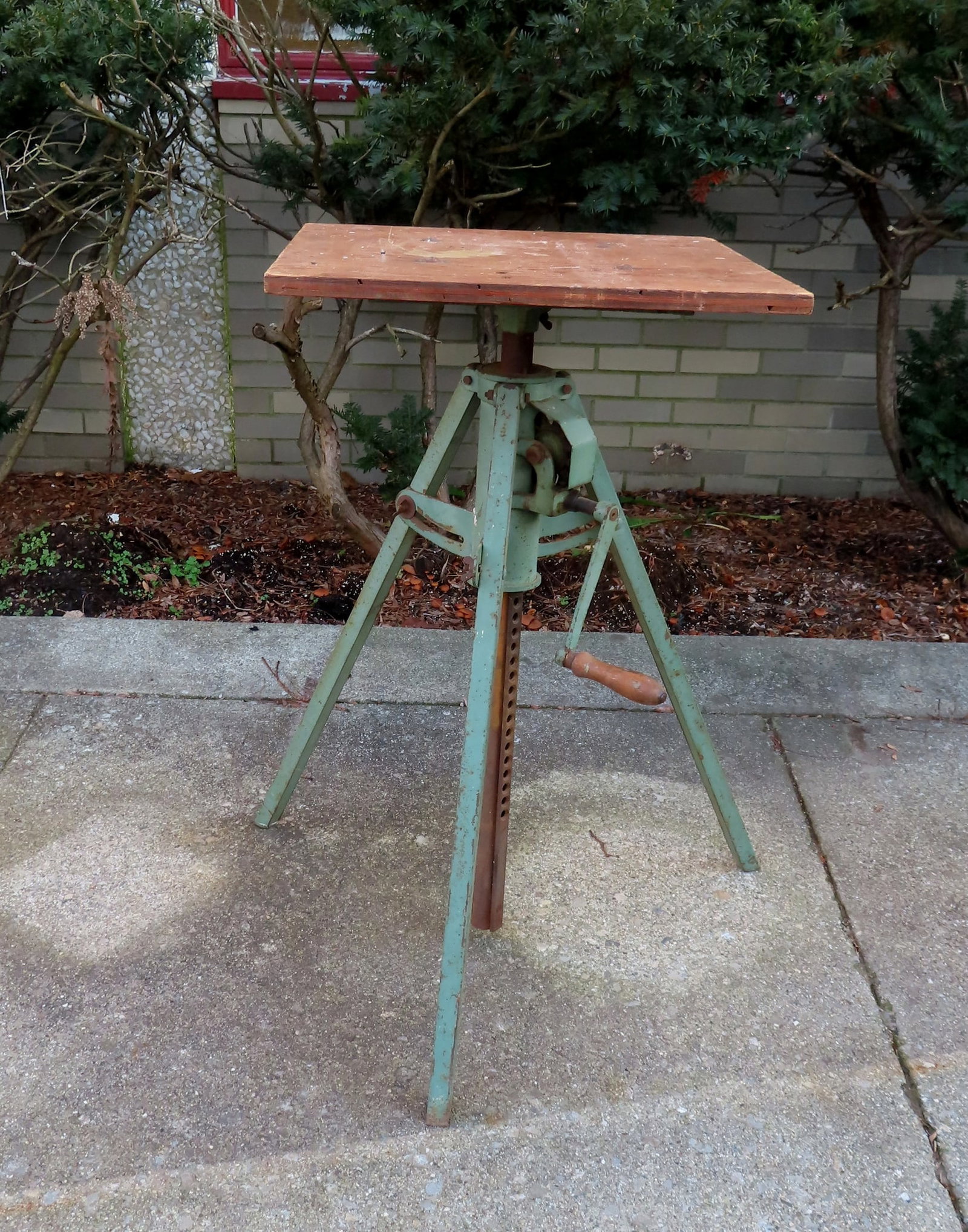 An adjustable sculptures work stand with crank handle, iron base in original green paint and wooden: An adjustable sculptures work stand with crank handle, iron base in original green paint and wooden revolving top, circa 1940-50. Good working condition. Measures 20" square top x 28"W at base x 34 1/