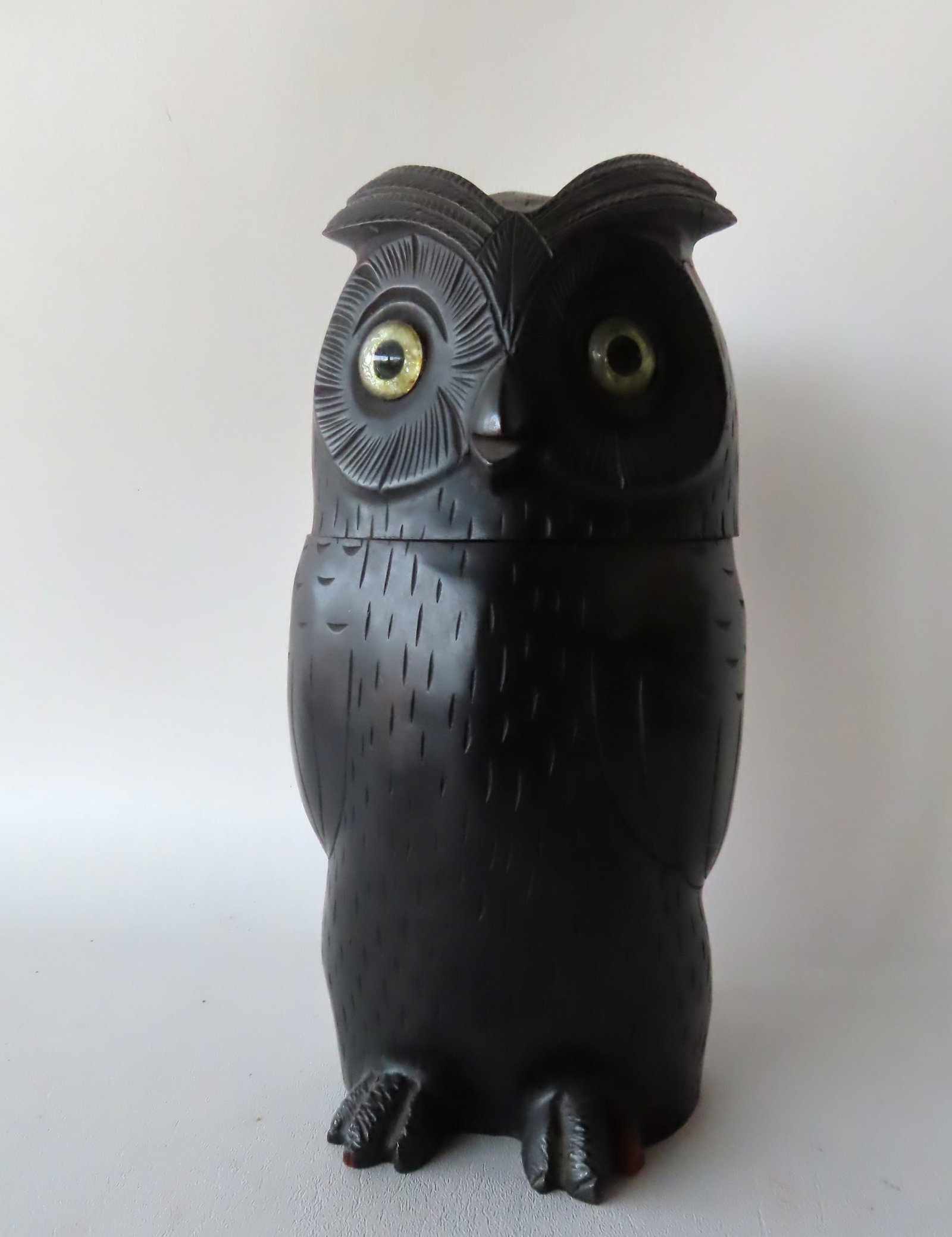 A very fine carved wooden owl with glass eyes, possibly a humidor. The back with tight expansion: A very fine carved wooden owl with glass eyes, possibly a humidor. The back with tight expansion crack, wear to one toe, overall very good condition. Measures 5 1/2"W x 5 1/2"D x 12 1/2"H. Provenance: