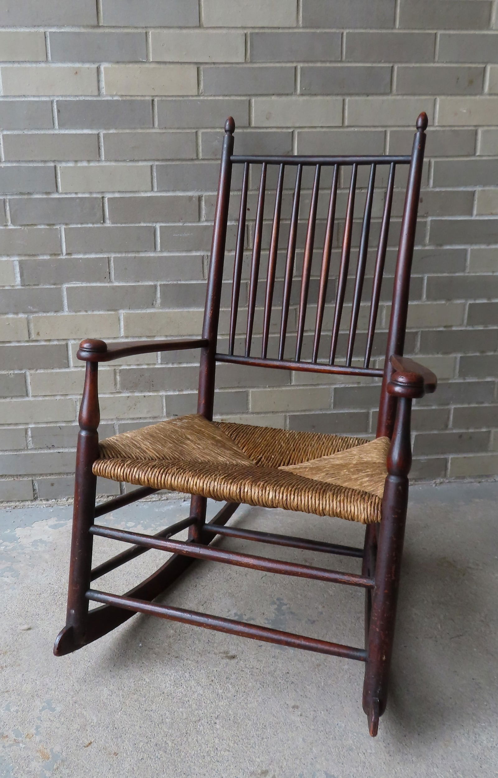 A Shaker spindle-back rocker with rush seat, late 19th century, original darkened finish and in very (1 of 5)