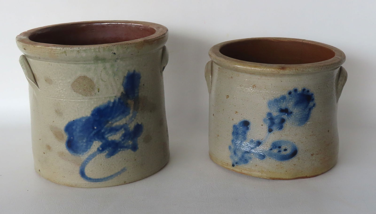 Two stoneware crocks. The first decorated with a blue bird on branch, several rim chips, tight (1 of 11)