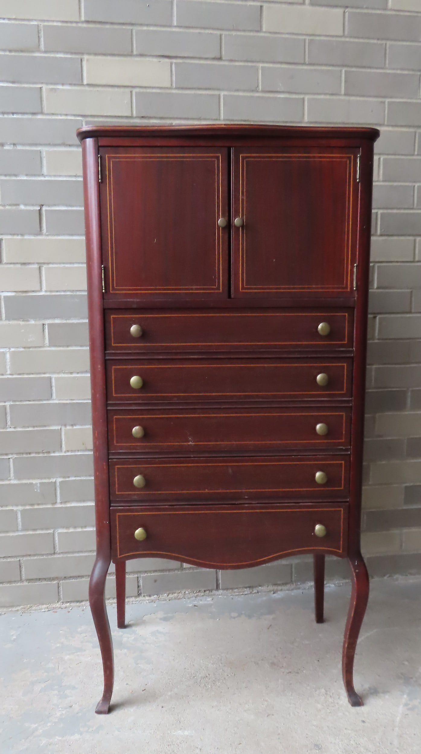 An Edwardian mahogany music cabinet having 2 doors with fitted interior over 5 drawers with banded: An Edwardian mahogany music cabinet having 2 doors with fitted interior over 5 drawers with banded inlay mounted on cabriole legs, circa 1900. Measures 21"W x 15 1/8"D x 43 1/8"H. Good condition.
