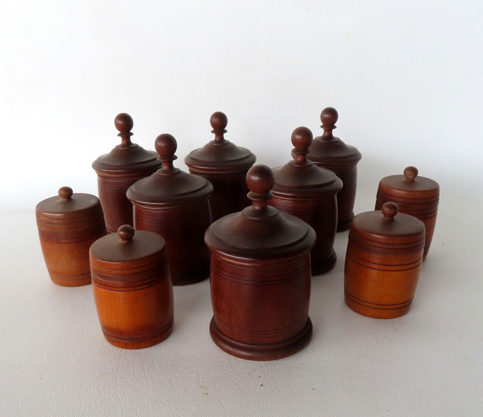 Grouping of 10 carved wooden spice canisters, a set of 6 and a set of 4 in barrel shape, all 19th (1 of 11)