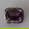 A beautiful 14k gold amethyst brooch. The purple stone surrounded by tiny pearls and a hand painted