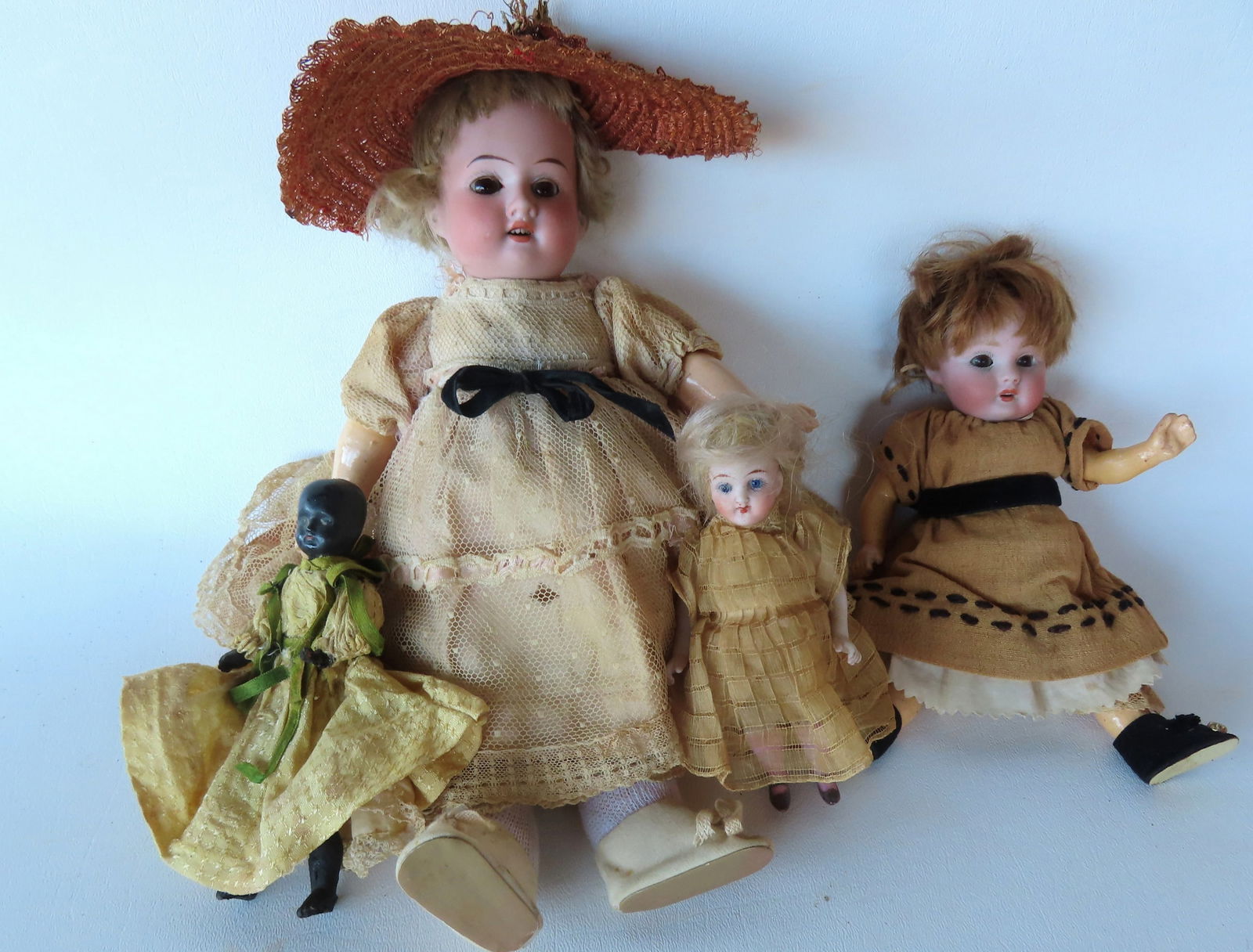 Four small vintage dolls including: A bisque German doll with sleepy eyes, open mouth, bent arms and (1 of 20)