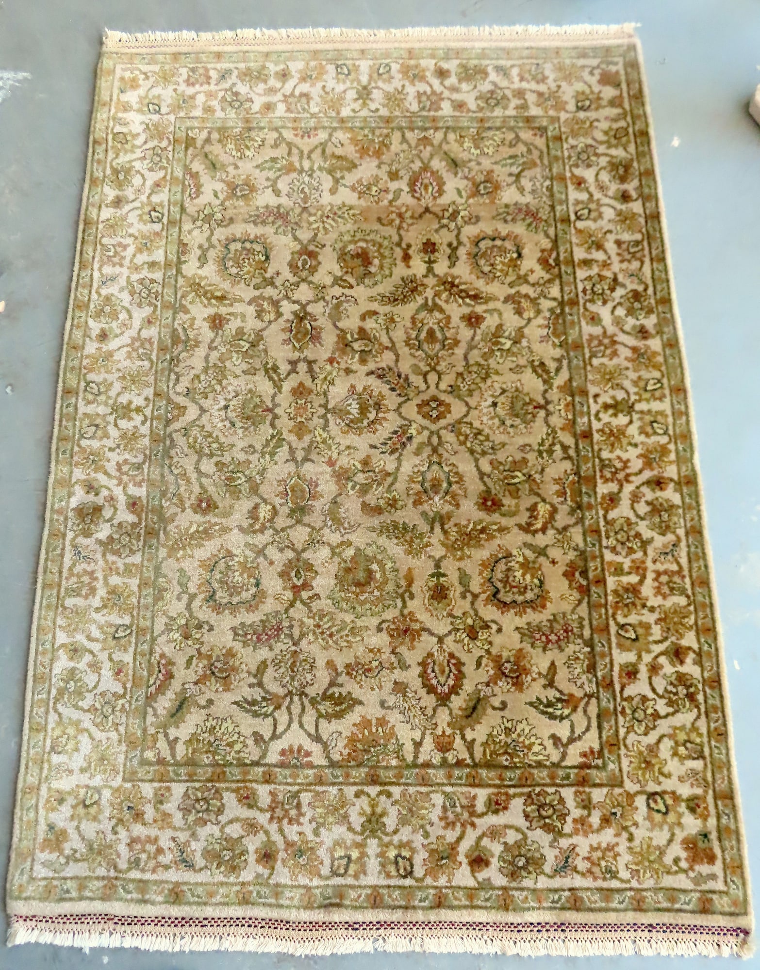A newer wool oriental scatter rug in floral design with fringe, appears to be hand knotted (1 of 4)