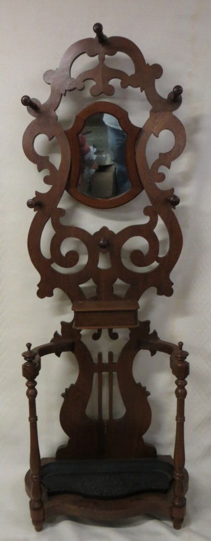 Victorian butternut wood hall tree with mirror bac: Victorian butternut wood hall tree with mirror back and glove box - 6 wooden hat racks - cast iron drip tray on base. 6' 4"H.