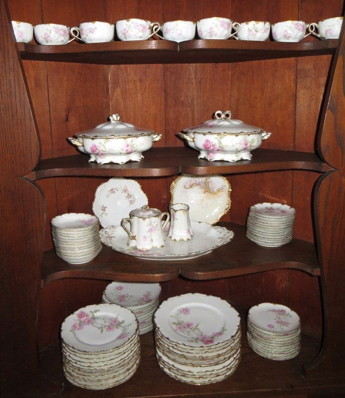 Set of Haviland Limoges china "Baltimore Rose".: SET of 85 pieces of signed Haviland Limoges china in the "Baltimore Rose" pattern - decorated with pink roses and hand painted gold trim, circa 1900-30. The set consists of 9 cups (2 W/tiny chips + 1