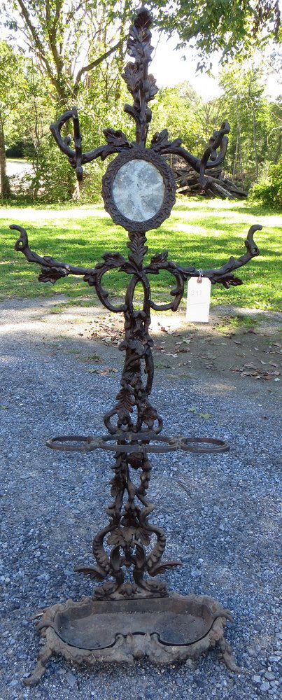 Victorian cast iron hall tree with 3 hat hooks, 2: Victorian cast iron hall tree with 3 hat hooks, 2 missing hat hooks, one repair to arm, decorated with leaves and acorns, footed base with cast iron drip pan, base with fox head center, 19th century.