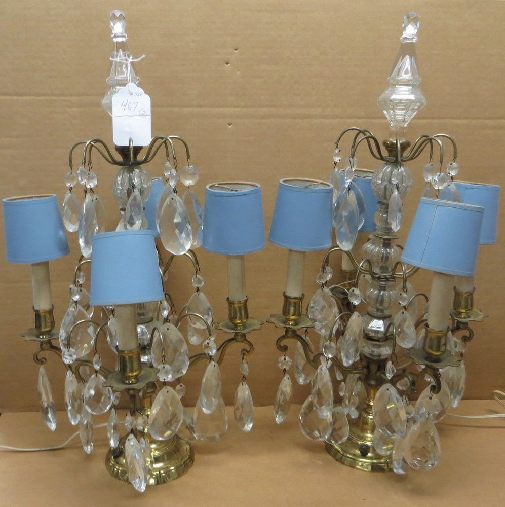 Pair of ornate brass table lamps with tear-drop cr: Pair of ornate brass table lamps with tear-drop crystal prisms and glass finials. Some chips to glass prisms - 4 branches - 22.5"H x 11.5"W. Provenance: From the estate of Elaine and Irving Sperber, S