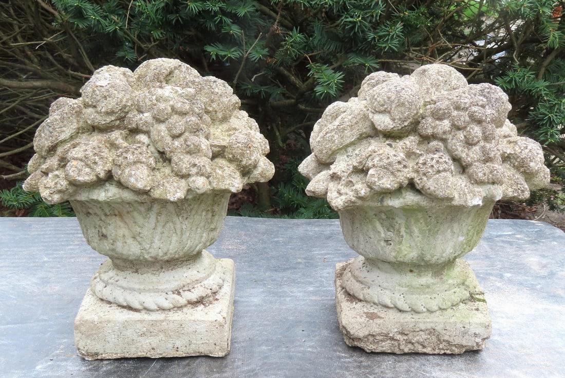 A pair of matching concrete basket of flower garden ornaments, circa 1950-70. Minor wear/chips to: A pair of matching concrete basket of flower garden ornaments, circa 1950-70. Minor wear/chips to several of the edges of extending flowers and edge of base, otherwise good condition. Measures 12 1/2"