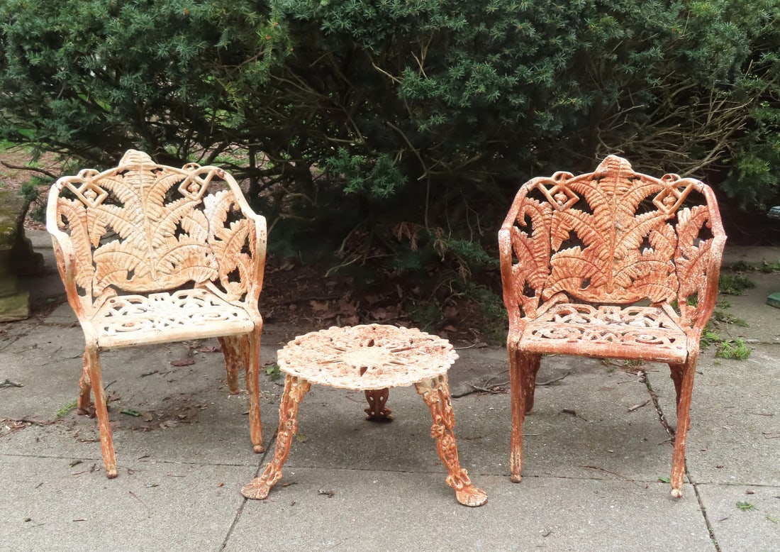 Two fern pattern cast iron garden chairs, late 19th century, together with a grape pattern cast iron: Two fern pattern cast iron garden chairs, late 19th century, together with a grape pattern cast iron patio end table, circa 1930-50. All in very good condition with layers of old paint. The chairs 33"