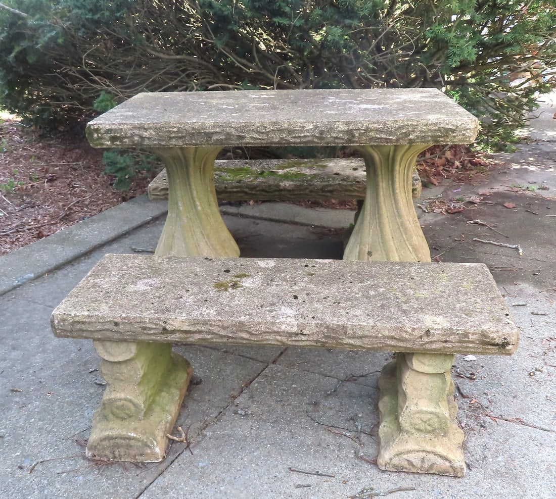 A rustic concrete or cast stone garden patio set consisting of a pedestal base table and 2 matching: A rustic concrete or cast stone garden patio set consisting of a pedestal base table and 2 matching benches, all with lichen on top surfaces, circa early to mid 20th century. The benches in the form o