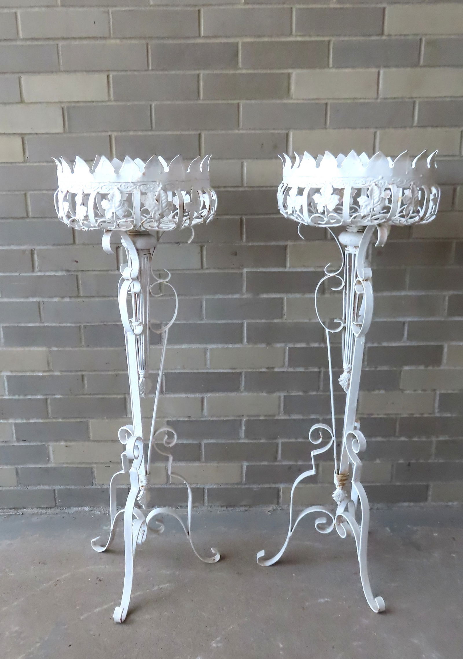 Two ornate wrought iron planters, early to mid 20th century. Both in very good condition in white: Two ornate wrought iron planters, early to mid 20th century. Both in very good condition in white paint. Measures 38 1/2"H x 13" diameter at top.