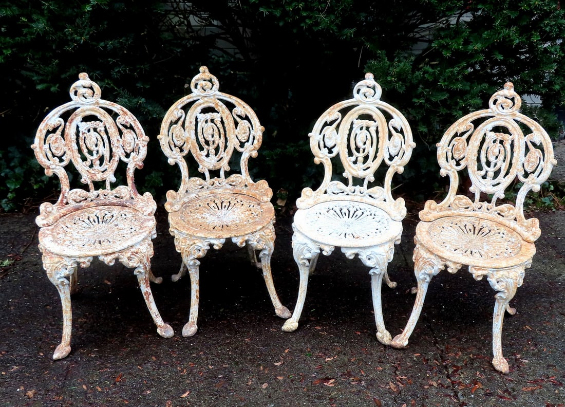 Set of 4 classical cast iron garden chairs signed on seats "Atlanta Stove Works", early 20th: Set of 4 classical cast iron garden chairs signed on seats "Atlanta Stove Works", early 20th century. Layers of old paint, some surface rust, one chair missing screw that holds back to seat, else all 