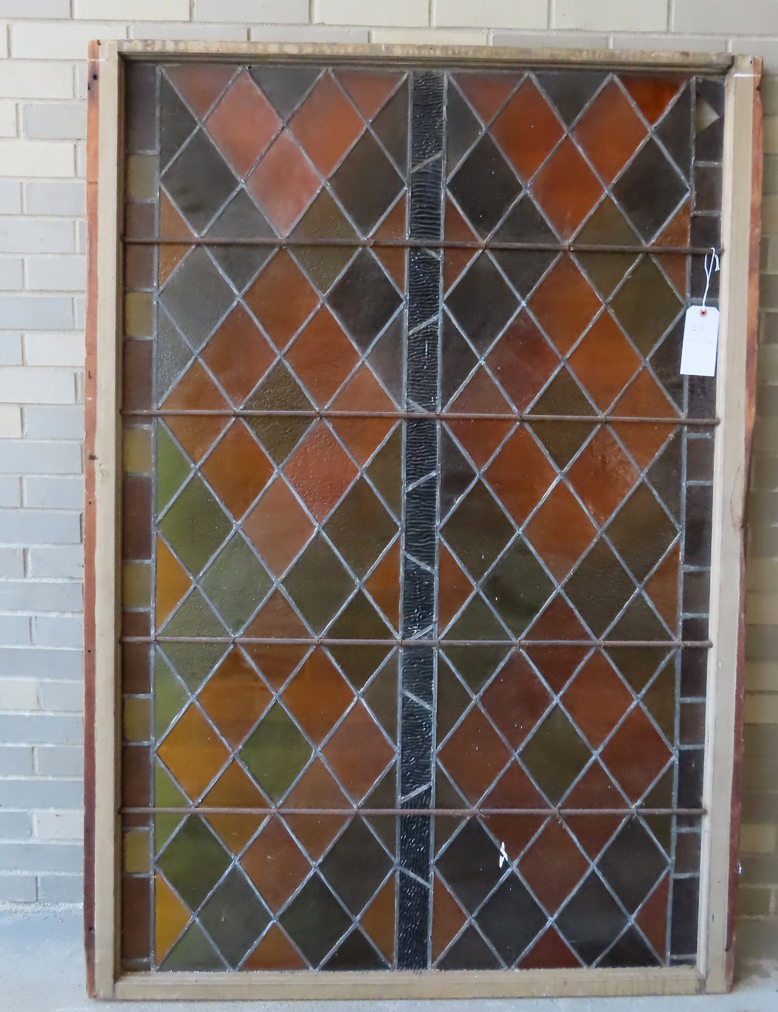 A large leaded and stained glass window (or door -has holes where hinges were once attached) with: A large leaded and stained glass window (or door -has holes where hinges were once attached) with original iron rebar supports, circa 1920. Diamond pattern with rectangular panels forming border. Some