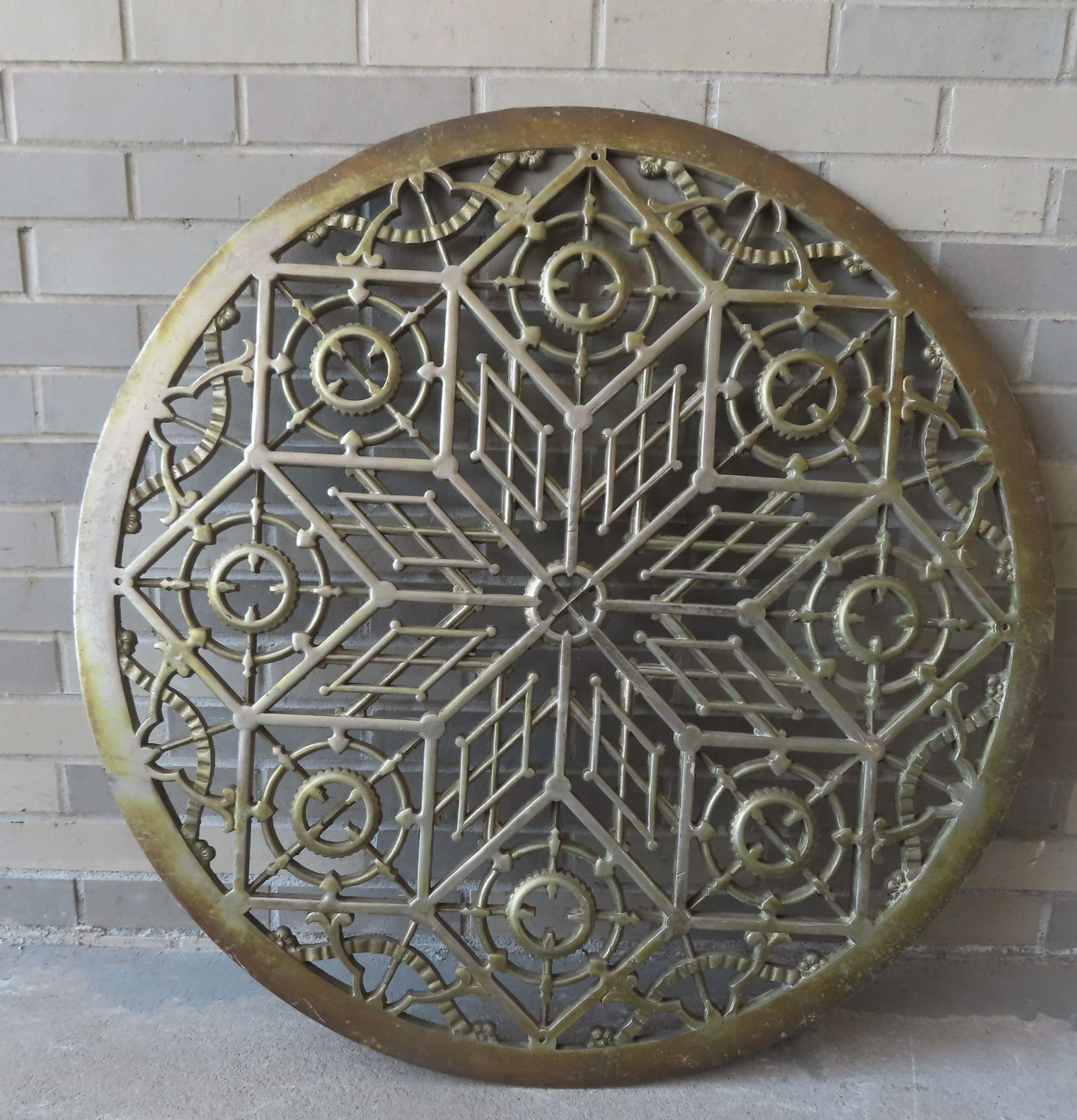 A large ornate cast iron grate with star center and bronze finish, likely from a bank or other: A large ornate cast iron grate with star center and bronze finish, likely from a bank or other commercial building, circa 1880-1920. Very good original condition - 35 1/4" diameter.