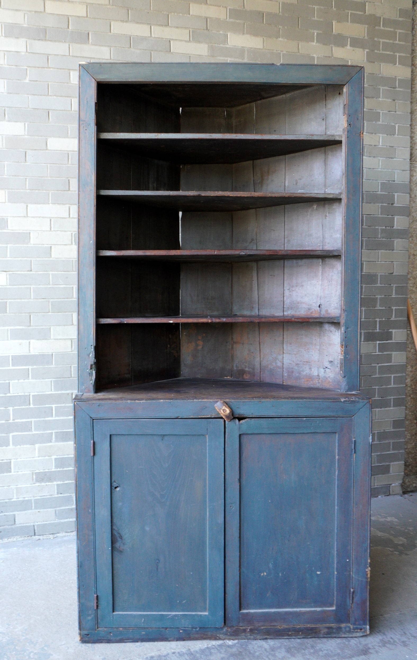 A primitive early 19th century Country corner cabinet having an open top over 2 lower paneled doors: A primitive early 19th century Country corner cabinet having an open top over 2 lower paneled doors in newer blue-gray paint, square nail construction - note the top originally had 2 doors which are m