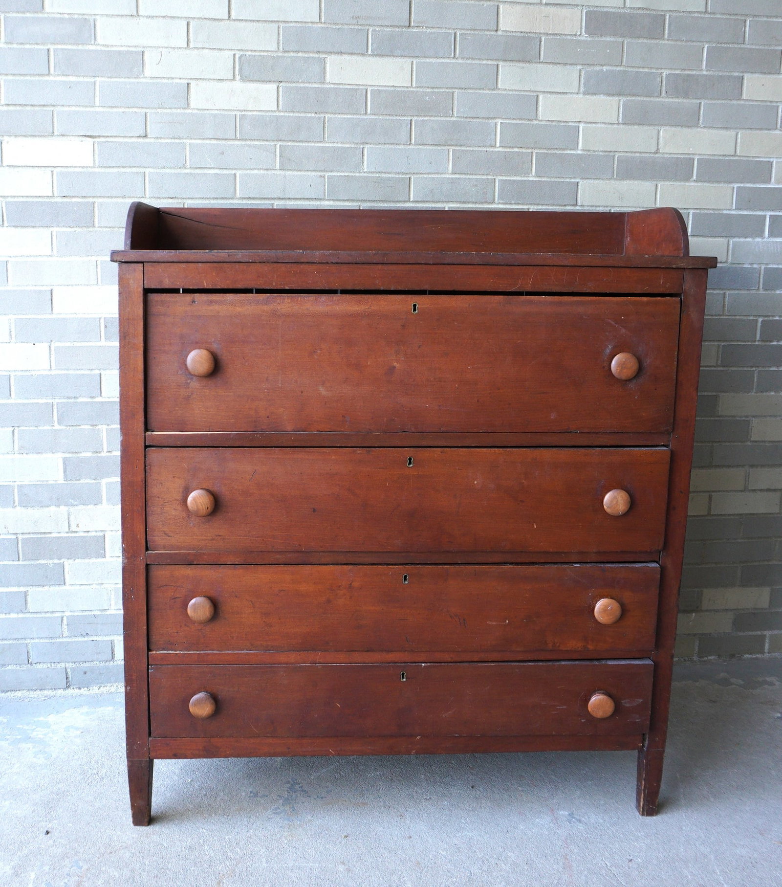 A 4 drawer country chest with wooden pulls, mid 19th century or earlier mounted on short tapered: A 4 drawer country chest with wooden pulls, mid 19th century or earlier mounted on short tapered legs. Good condition. Measures 41 3/8"W x 18 1/2"D x 47 1/2"H. Provenance: From the Carole Ostergren co