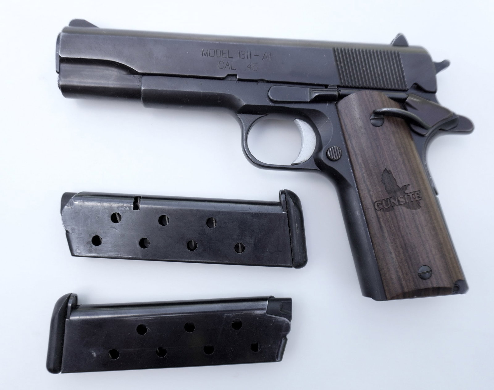 A Springfield Armory semi-automatic pistol, Model 1911-A1, 45 Cal.: A Springfield Armory semi-automatic pistol, Model 1911-A1, 45 Cal., marked "Gunsite" on wooden grips. Sold with 4 magazines, 2 with this pistol, and 2 others for an unknown pistol. It is in very good 