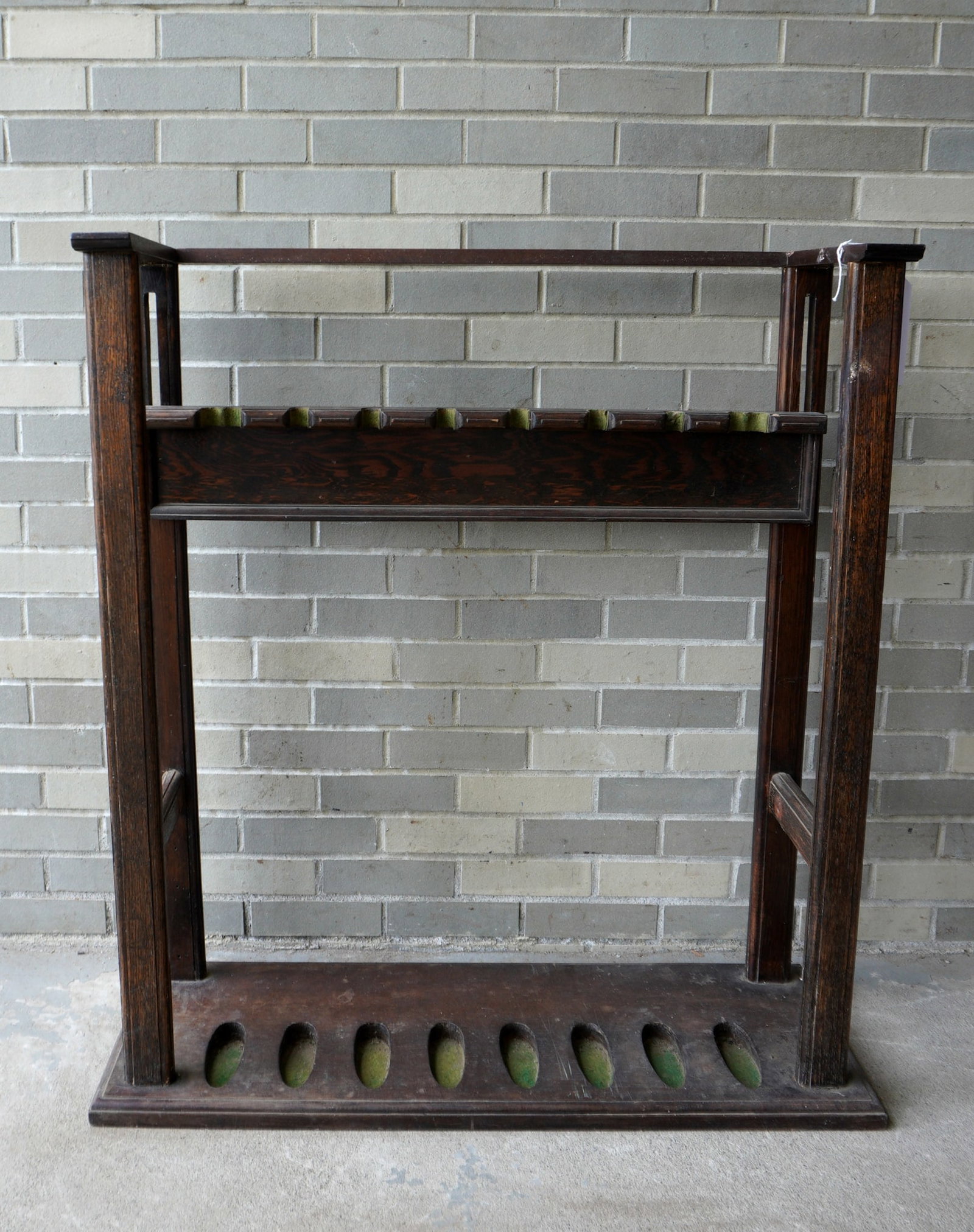 An adjustable wooden gun rack, early to mid 20th century. Missing a small sliver of wood where the: An adjustable wooden gun rack, early to mid 20th century. Missing a small sliver of wood where the center top brace is mortised into the sides, otherwise good condition. Slots for 2 double barrel shot