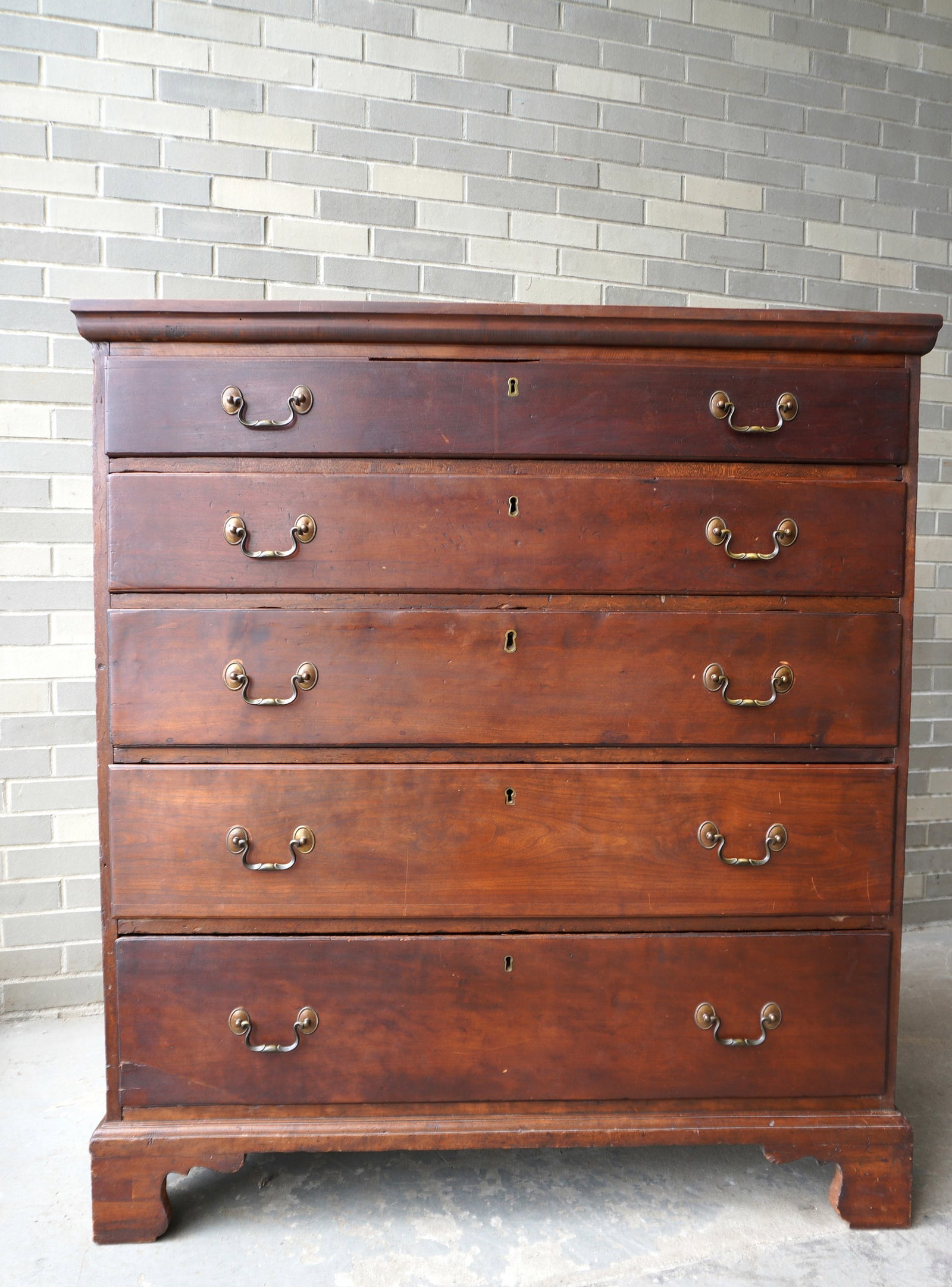 A cherry Chippendale 5 drawer chest with graduated and beaded drawers, dovetailed bracket base,: A cherry Chippendale 5 drawer chest with graduated and beaded drawers, dovetailed bracket base, dovetailed top, original bale pulls. All drawers with some restoration to sides and bottoms, one replace