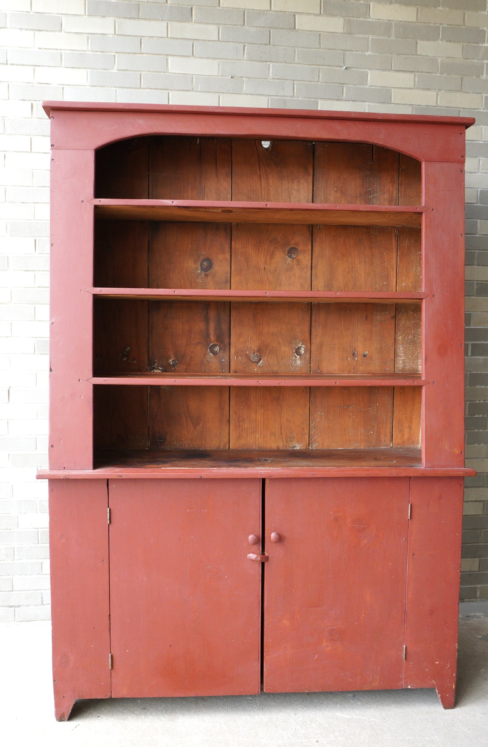 A primitive looking restored cupboard with open top over 2 doors mounted on cutout base. The base,: A primitive looking restored cupboard with open top over 2 doors mounted on cutout base. The base, which is also restored, appears to be original 19th century. The top section appears to have newer bo