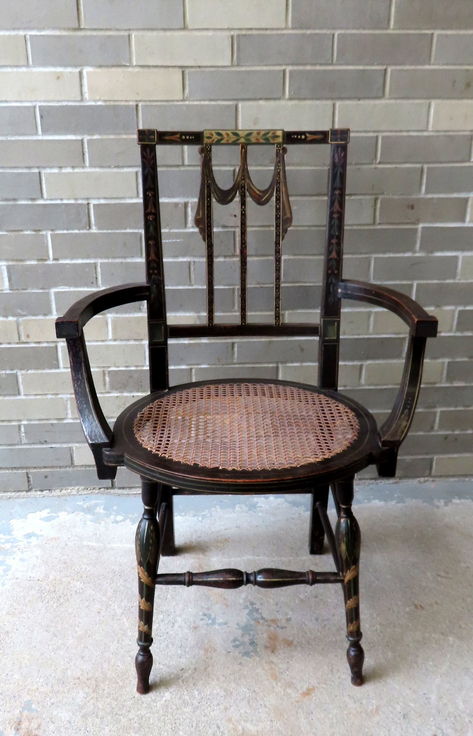 An unusual transitional federal side chair with bowed arms, cane seat, turned legs and stretchers: An unusual transitional federal side chair with bowed arms, cane seat, turned legs and stretchers with rectangular shaped back having vertical and painted slats with carved drapes. The chair in origin