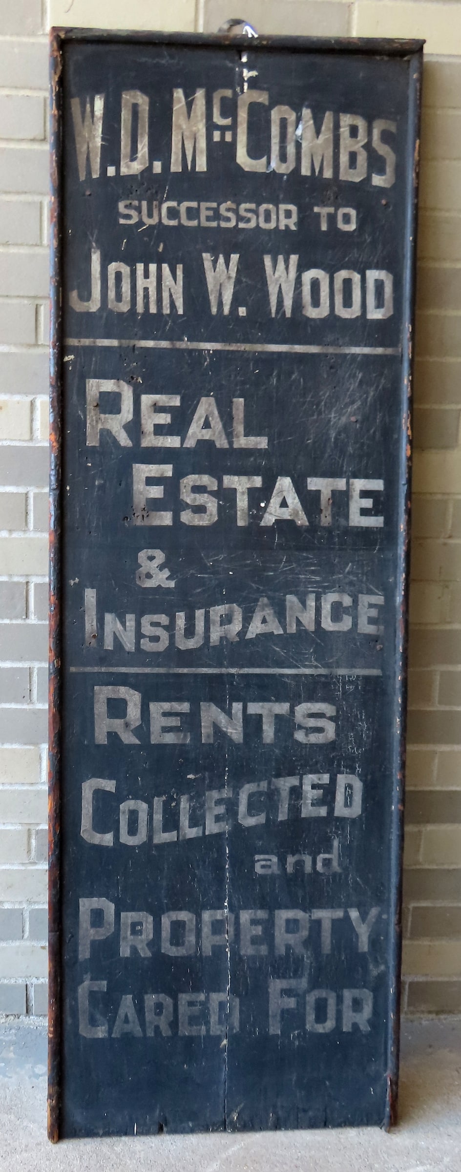 A vintage wooden real estate and Insurance sign in original paint, marked "W.D. McCOMBS / SUCCESSSOR: A vintage wooden real estate and Insurance sign in original paint, marked "W.D. McCOMBS / SUCCESSSOR TO JOHN W. WOOD / REAL ESTATE & INSURANCE / RENTS COLLECTED AND PROPERTY CARED FOR", white letterin