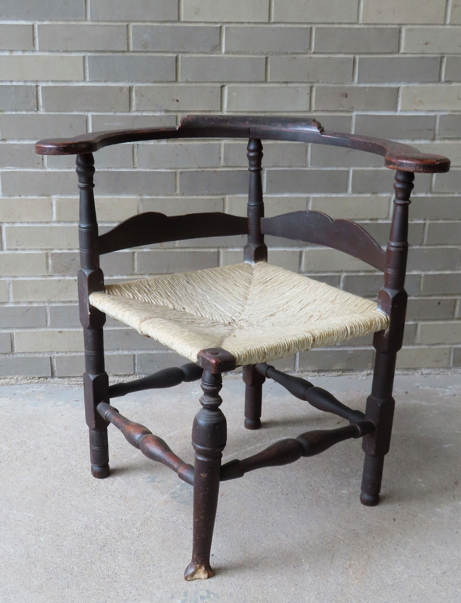 A very fine Connecticut Queen Ann corner chair with original rush seat, in a very old dark green: A very fine Connecticut Queen Ann corner chair with original rush seat, in a very old dark green paint over original red stain, and having shaped and curved arms, turned cross stretchers, and turned l