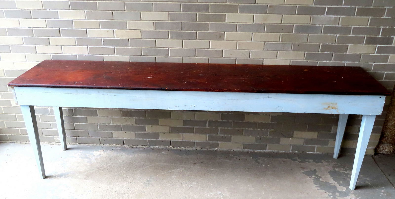 Primitive farm table with 2 board top in original brown stain, and having a wrap-around apron: Primitive farm table with 2 board top in original brown stain, and having a wrap-around apron attached to tapered and chamfered legs in old powder blue paint. The top and apron are 19th century, but t