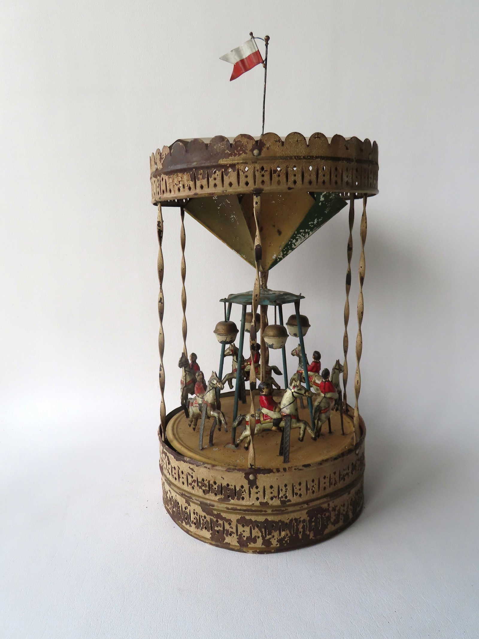 An early tin windup carousel in original paint, attributed to William Krauss, Germany, circa 1920: An early tin windup carousel in original paint, attributed to William Krauss, Germany, circa 1920 or earlier. Measures 20"H x 9" diameter. Spring intact, but windup mechanism non-working - some paint 