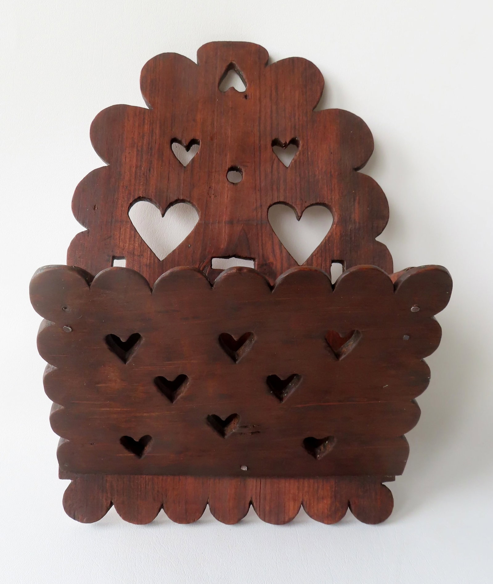 A carved folk art wooden wall shelf with heart cutouts, refinished with traces of original gray: A carved folk art wooden wall shelf with heart cutouts, refinished with traces of original gray paint, 19th century. Measures 19"H x 11 1/2"W x 6"D.