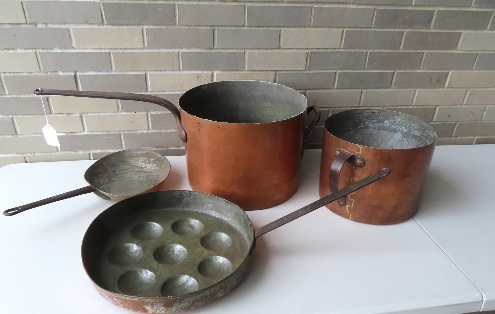 Grouping of 4 early copper pots and pans including: Long handled biscuit pan with forged iron handle: Grouping of 4 early copper pots and pans including: Long handled biscuit pan with forged iron handle having 8 biscuit molds hammered into base - 26 2"L; small hand made frying pan signed W.D. Trace - 