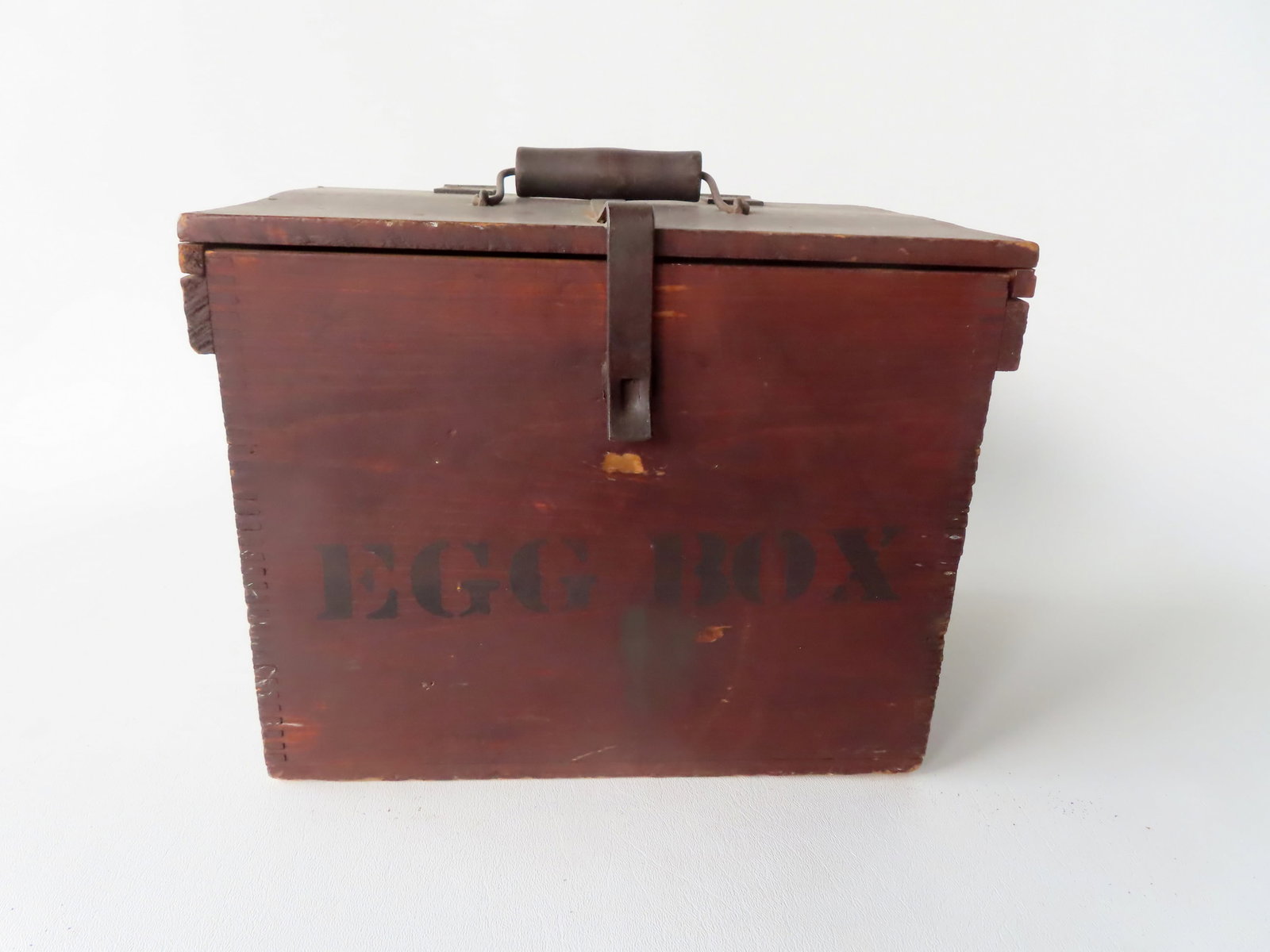 The best wooden egg box in original red stain marked in black stenciling "EGG BOX" with original: The best wooden egg box in original red stain marked in black stenciling "EGG BOX" with original bale handle and forged iron hasp. Paper label on interior signed "Emery P. Auger Sr. / Fitzwilliam, N.H