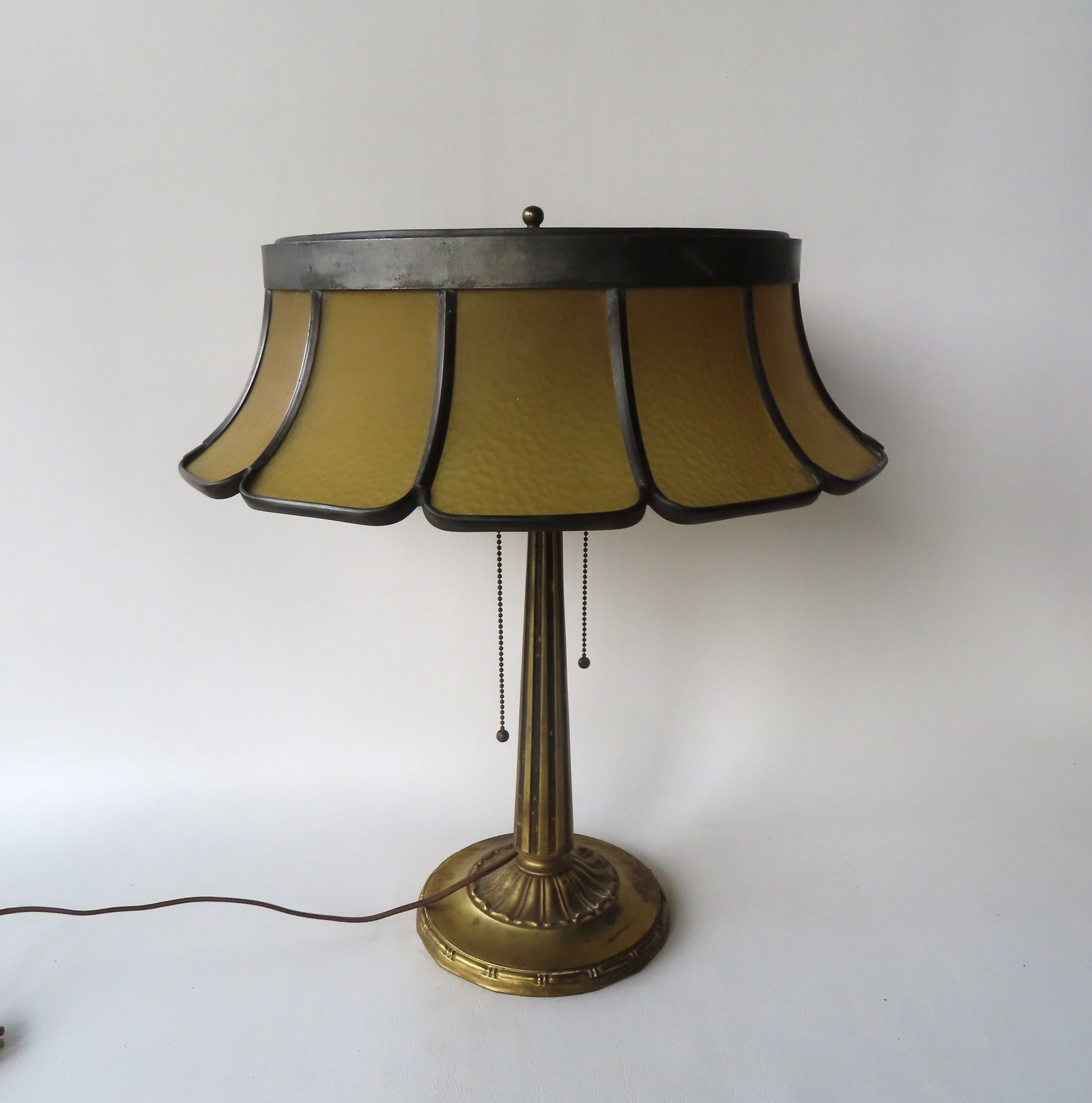 Table lamp with brass or bronze base with an unusual shade in the form of flower petals with curved: Table lamp with brass or bronze base with an unusual shade in the form of flower petals with curved glass inserts, circa 1920. Measures 21"H to top of finial - the shade 18" diameter x 5 1/2"H. Very g