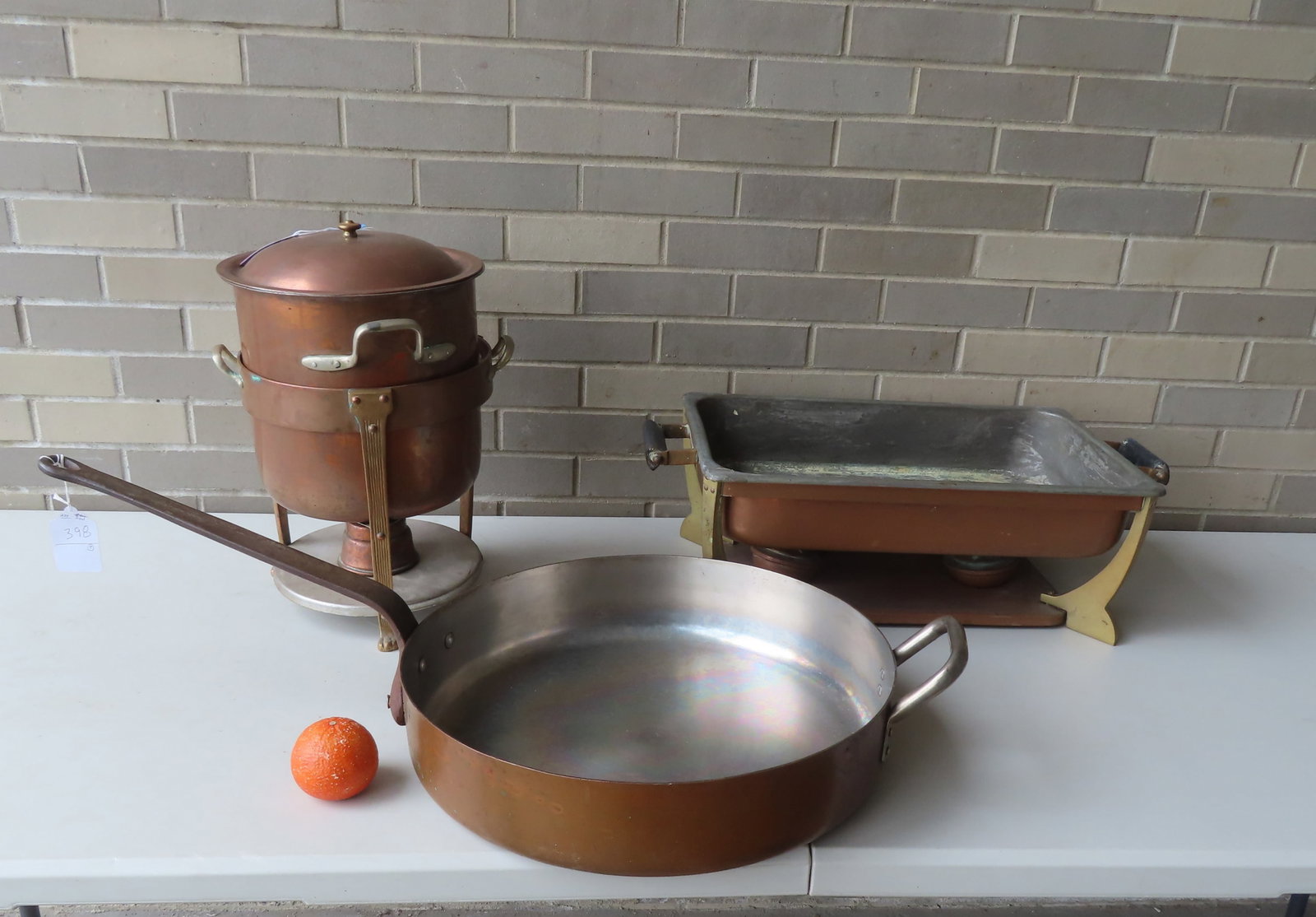 A grouping of commercial copper cooking pots and food heaters including: Frying pan with iron handle: A grouping of commercial copper cooking pots and food heaters including: Frying pan with iron handle and copper bowl - this is the largest measuring 34"L x 18" diameter x 10 1/2"H at highest point - v