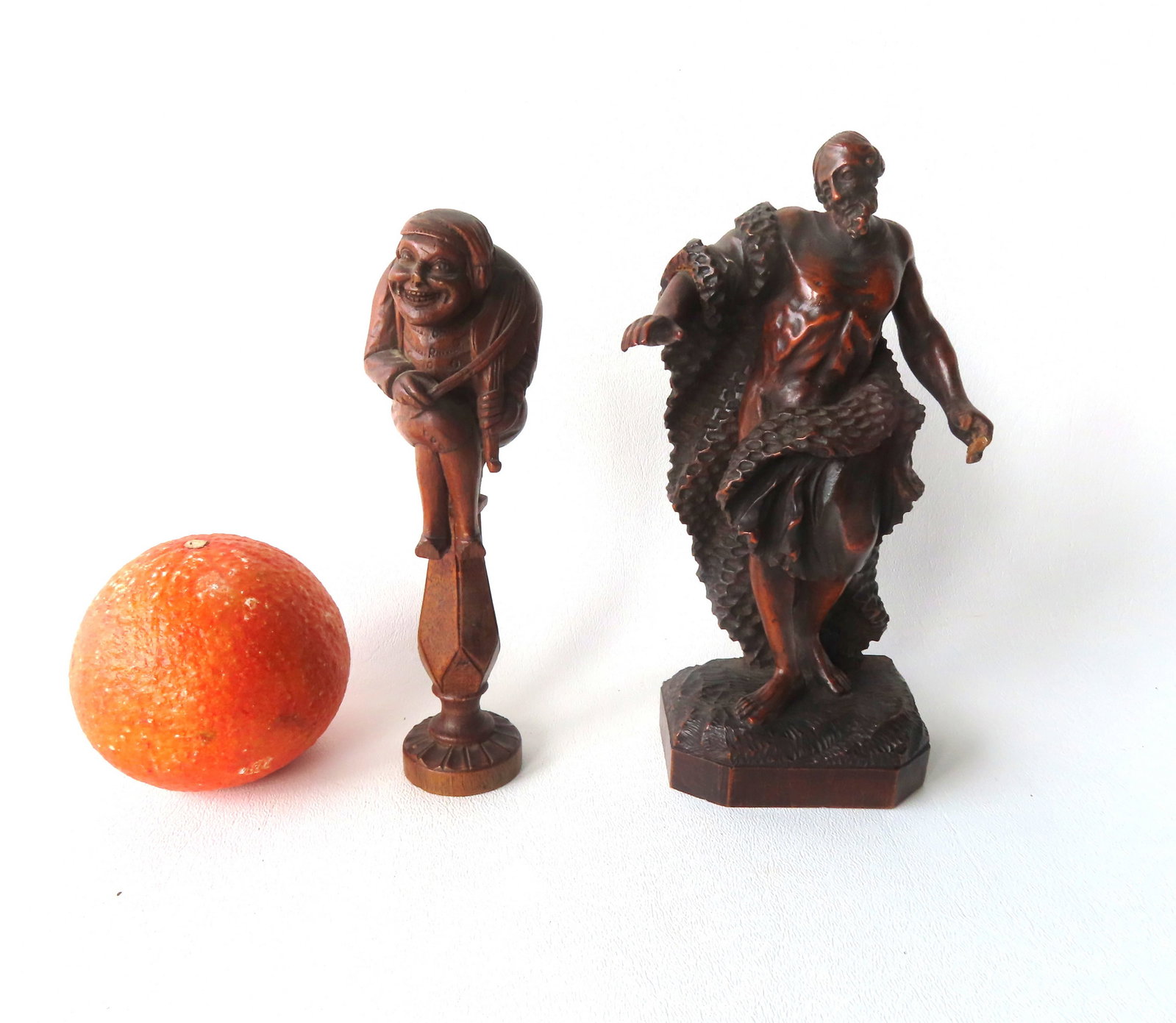 Two carved wooden sculptures, 19th century: The first, a nutcracker, depicting a whimsical man: Two carved wooden sculptures, 19th century: The first, a nutcracker, depicting a whimsical man playing a violin seated on pedestal - the pedestal screws into the rear section of the seated man to crus