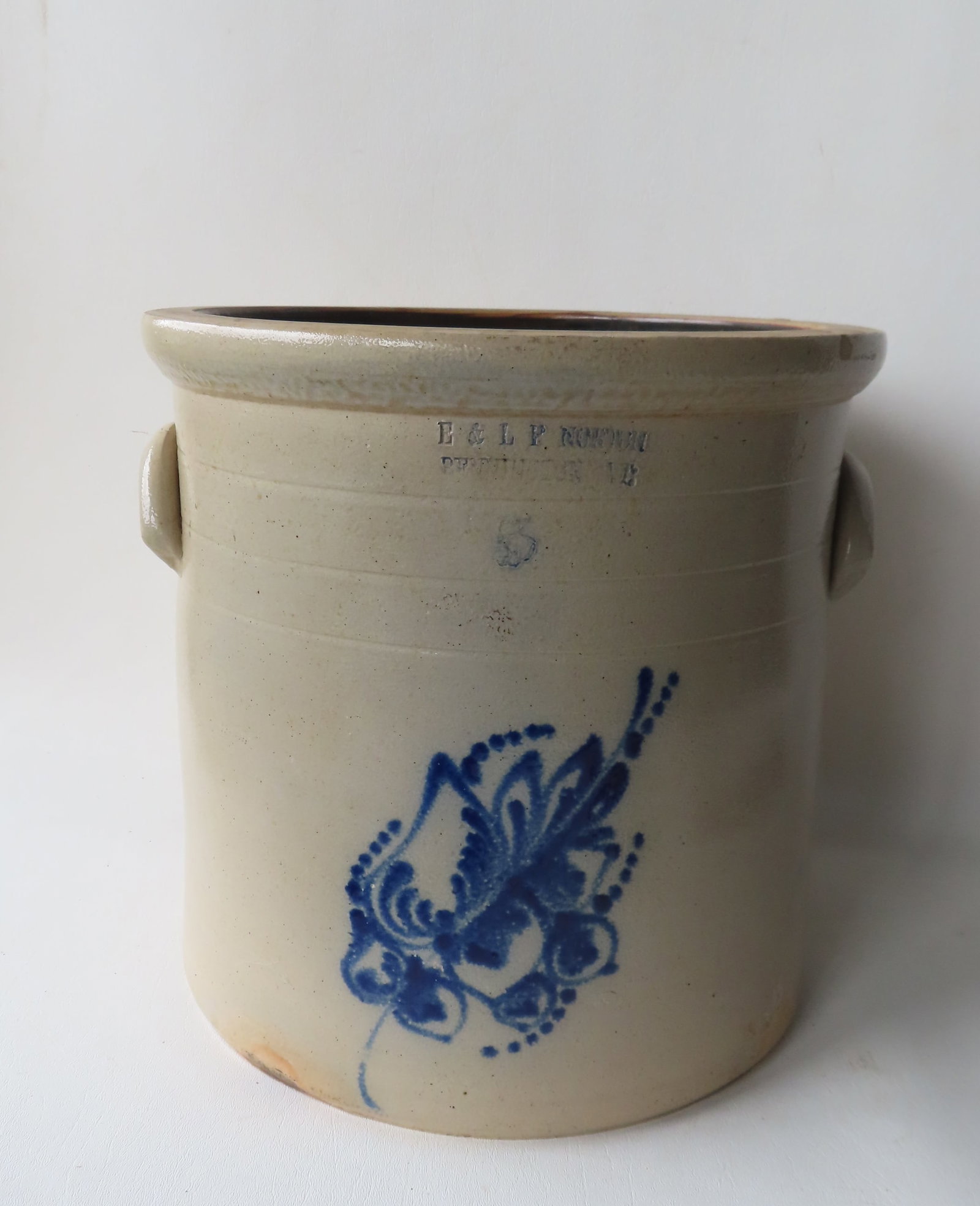 Stoneware 5 gallon crock marked "E & LP NORTON / BENNINGTON VT", decorated with a large cobalt blue: Stoneware 5 gallon crock marked "E & LP NORTON / BENNINGTON VT", decorated with a large cobalt blue flower. Chip to interior edge of crock, else very good condition. Measures 12 3/4"H x 12"W.