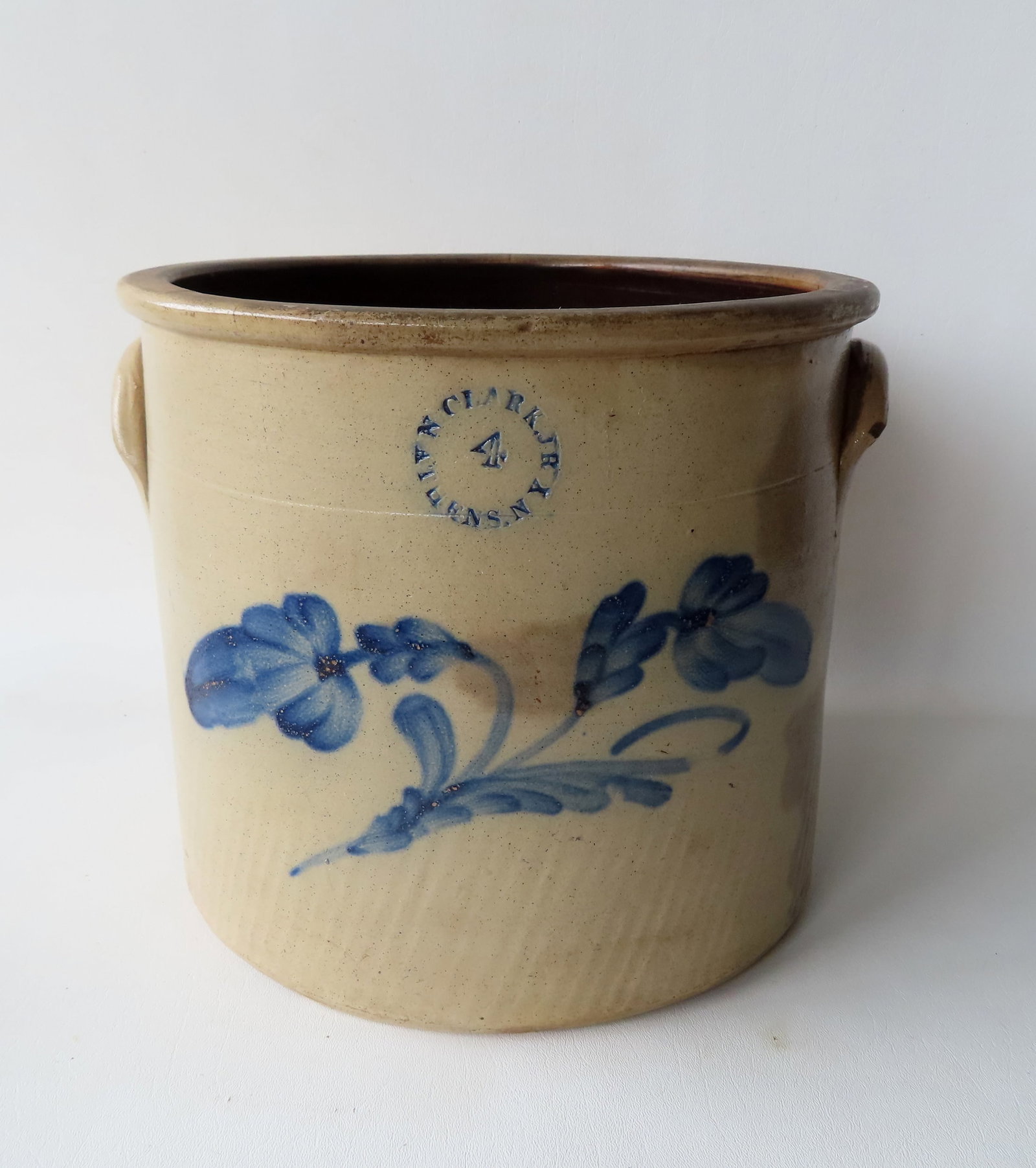 Stoneware 4 gallon crock marked "N. CLARK JR / ATHENS. N Y", decorated with a large cobalt blue: Stoneware 4 gallon crock marked "N. CLARK JR / ATHENS. N Y", decorated with a large cobalt blue flower - 2 tight hairlines extending from rim, tiny chip to edge of one ear, and staining on one side an