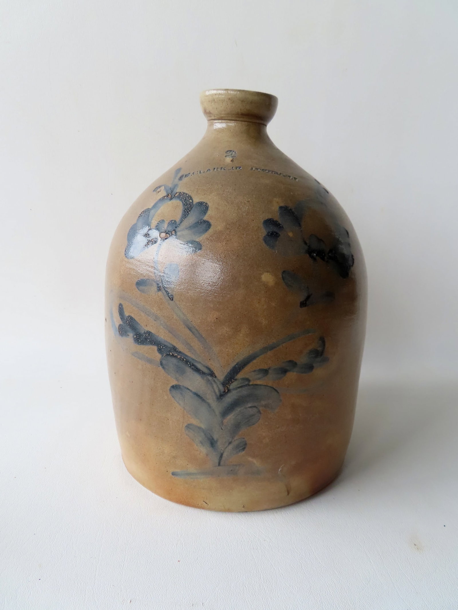 Stoneware 2 gallon jug marked "N. CLARK JR / ATHENS N.Y.", decorated with a large cobalt blue double: Stoneware 2 gallon jug marked "N. CLARK JR / ATHENS N.Y.", decorated with a large cobalt blue double flower - good condition. 13 1/4"H. Provenance: From the Carole Ostergren collection, Wallkill NY.