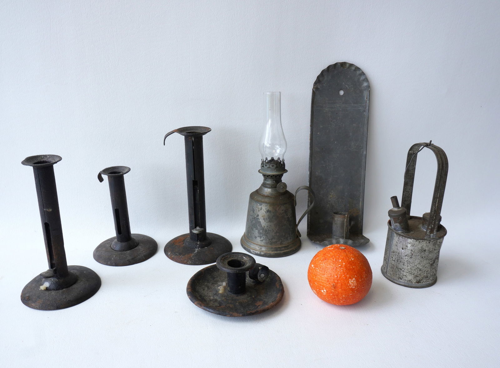 Grouping of 7 tin & pewter lighting devices including a fluid lamp with handle signed Wallace: Grouping of 7 tin & pewter lighting devices including a fluid lamp with handle signed Wallace Pewter, a candle wall sconce (unsure of age but probably late 19th to early 20th century), 3 hog scrapper