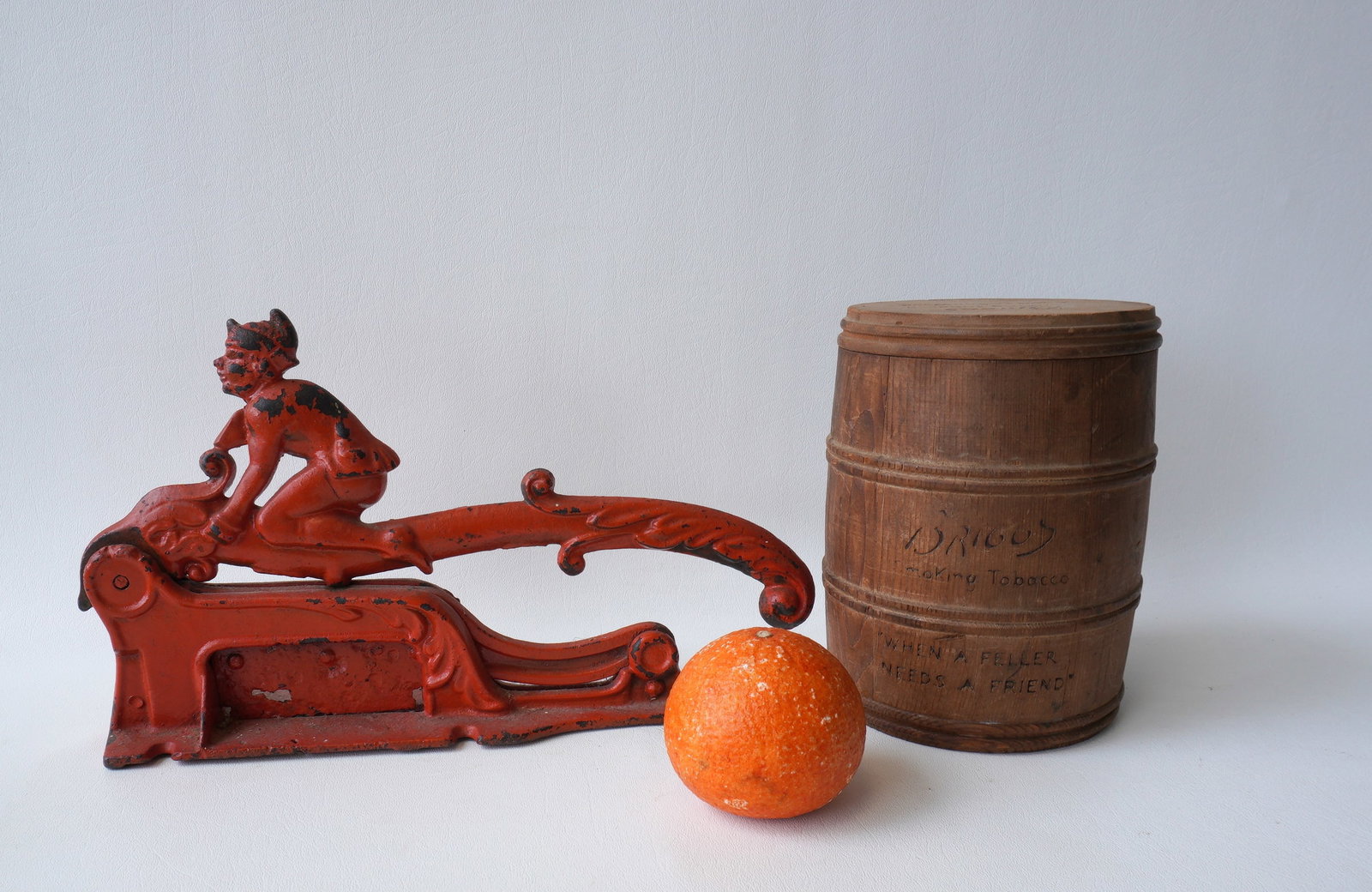 An elf tobacco cutter in red paint - some rusting and losses to blade otherwise good working: An elf tobacco cutter in red paint - some rusting and losses to blade otherwise good working condition - 13"L x 7 1/2"H, and a signed "Briggs" barrel shaped humidor - very good condition - 7"H x 5 1/2