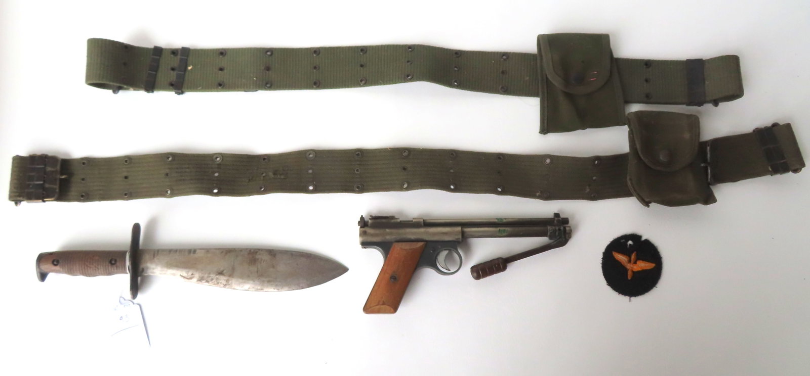 A grouping of military and weapons related collectibles including: A Benjamin Franklin air pellet: A grouping of military and weapons related collectibles including: A Benjamin Franklin air pellet gun with pump action - non-working condition (missing part that holds the pump lever in place) - 10"L;