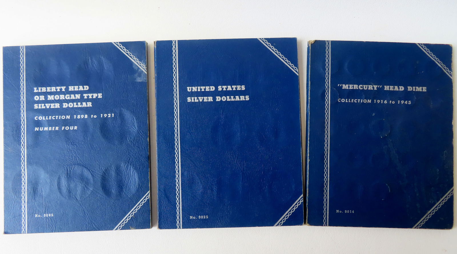 Three coin books with silver dollars and Mercury dimes. Book 1 contains 7 Liberty Head silver: Three coin books with silver dollars and Mercury dimes. Book 1 contains 7 Liberty Head silver dollars - 1899-1901; book 2 contains 19 Liberty Head silver dollars 1878-1890; and book 3 contains 45 Merc